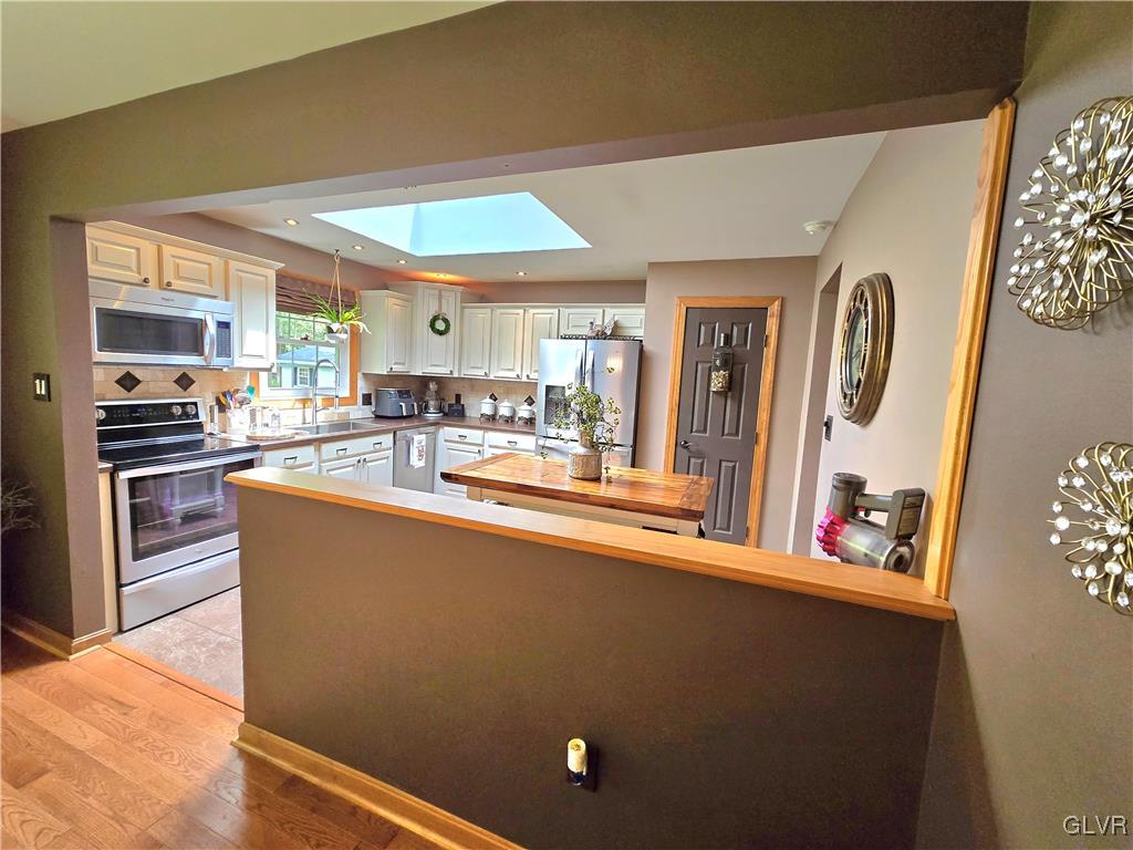 2231 Mountain Road Slatington, PA 18080 - Photo 5 of 41 a living room with stainless steel appliances a dining table wooden floor and a large window