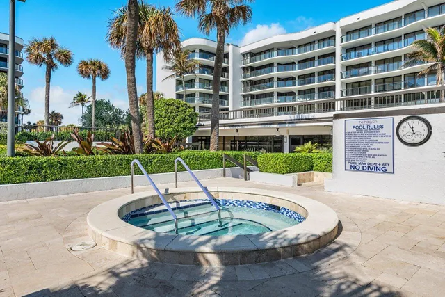 a view of a building with a yard and palm trees