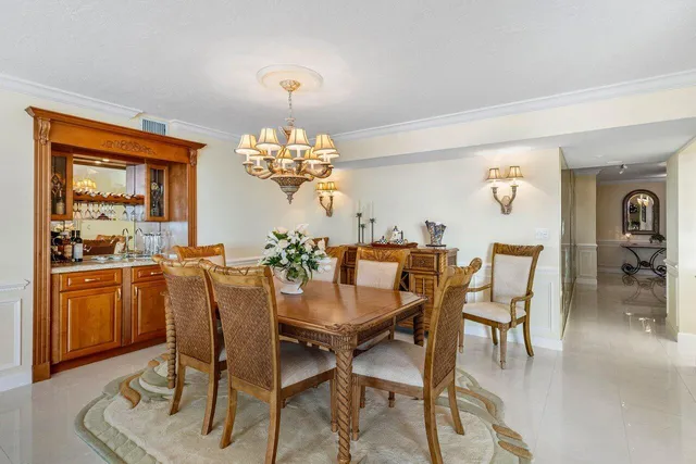 a dining room filled chandelier and wooden floor