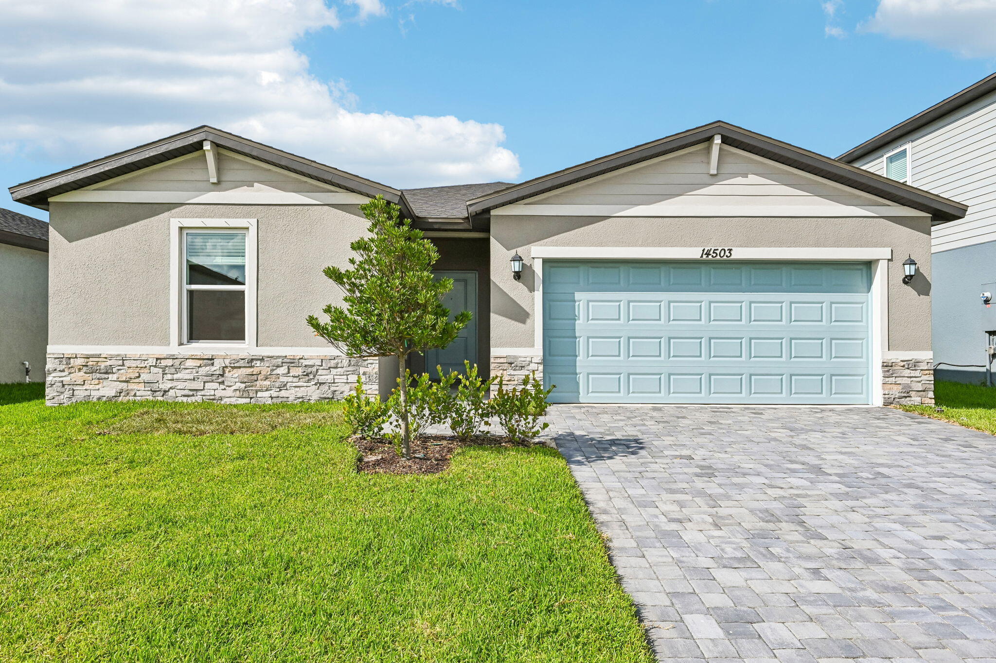 14503 Southwest New Dawn Road Indiantown, FL 34956 - Photo 1 of 42 a front view of a house with a yard and garage