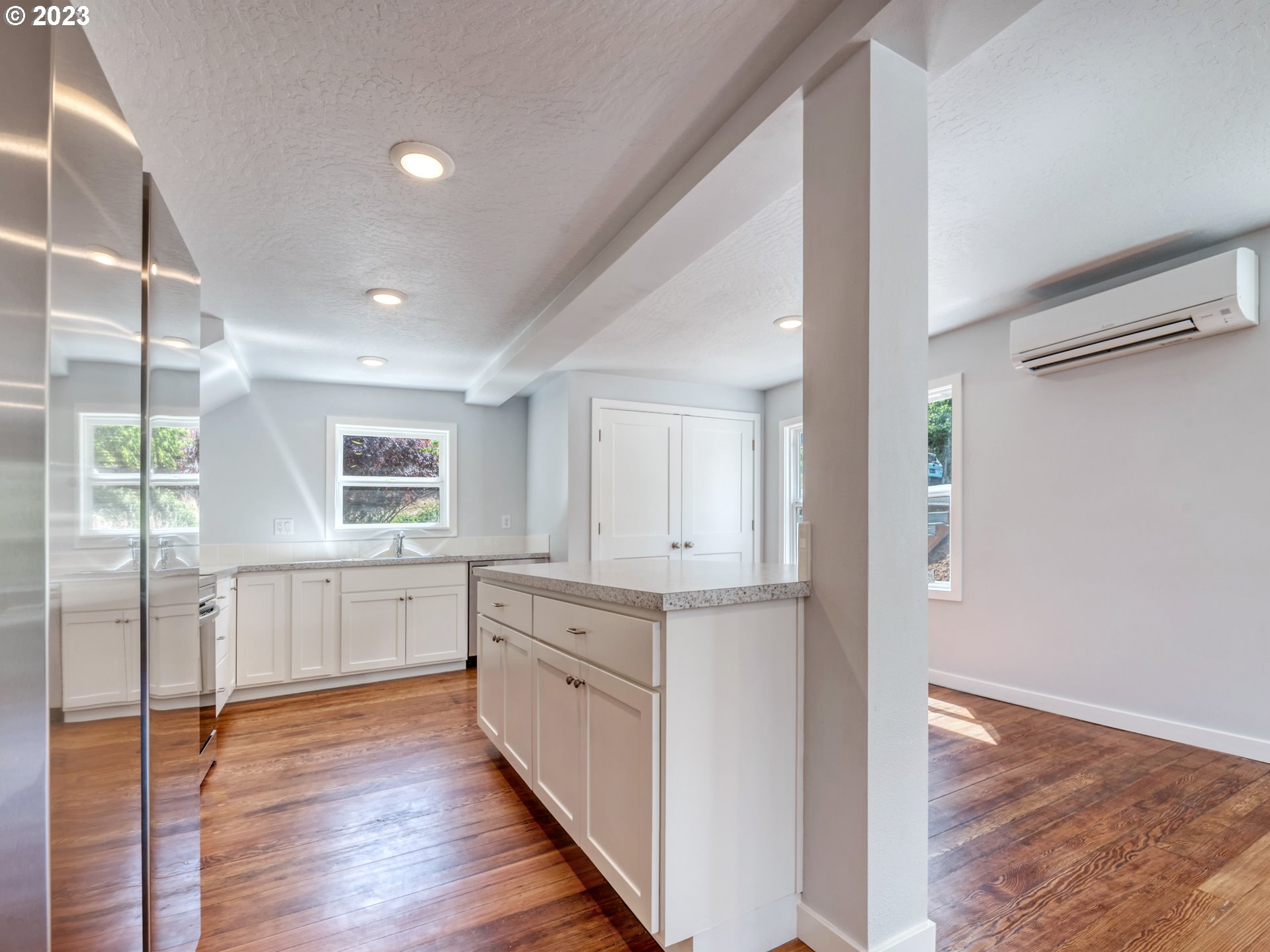 2285 City View Street Eugene, OR 97405 - Photo 16 of 47 a kitchen with white cabinets and wooden floor