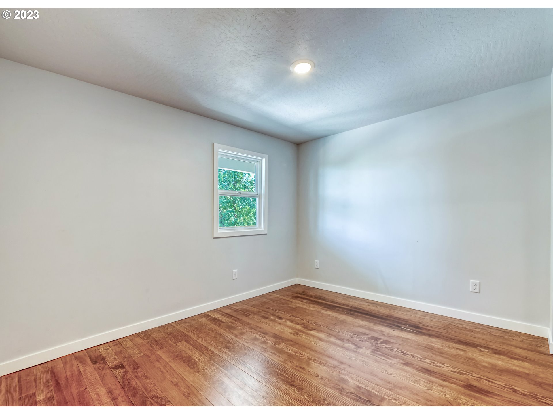 2285 City View Street Eugene, OR 97405 - Photo 18 of 47 an empty room with wooden floor and windows