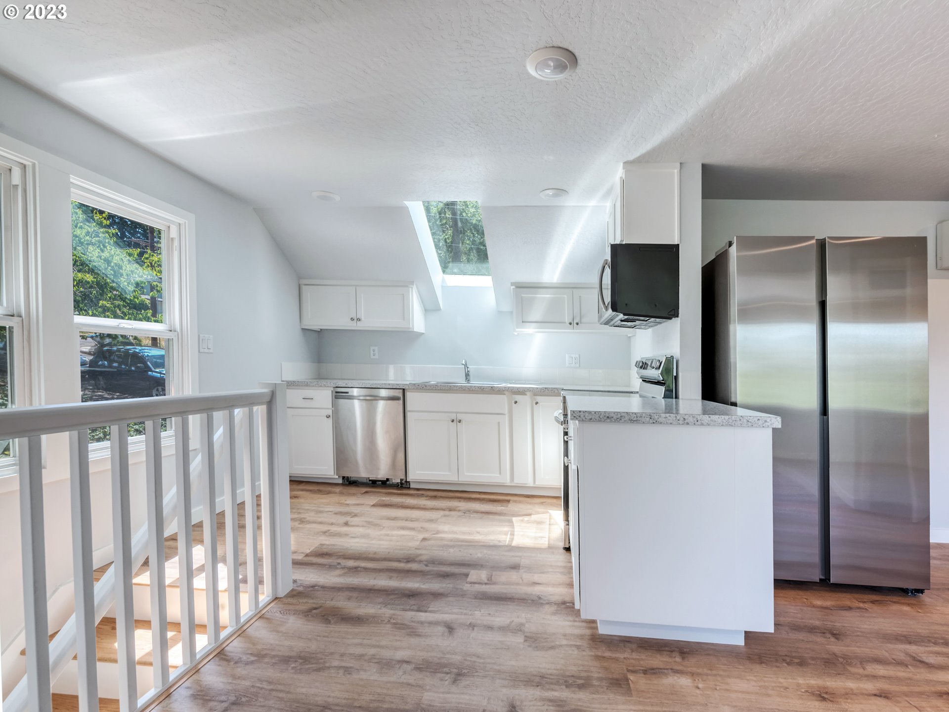 2285 City View Street Eugene, OR 97405 - Photo 28 of 47 a kitchen with kitchen island a counter top space a sink and a refrigerator