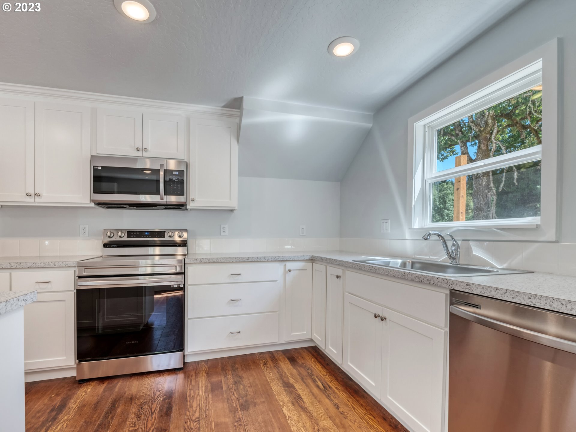 2285 City View Street Eugene, OR 97405 - Photo 31 of 47 a kitchen with granite countertop a stove a sink and a microwave