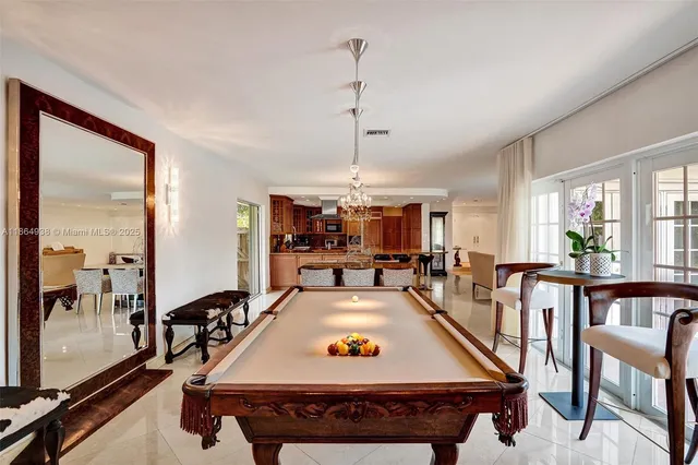 a living room with furniture a pool table and a chandelier