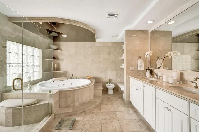 a spacious bathroom with a double vanity sink mirror and bathtub
