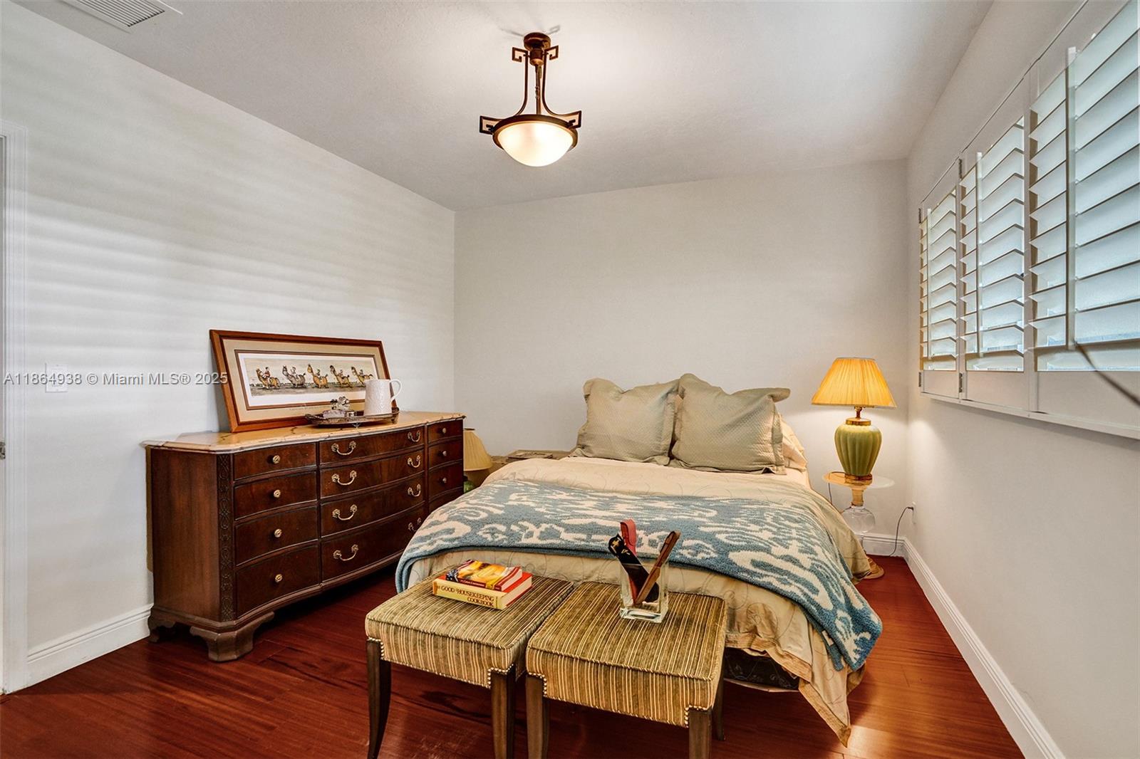 12840 Hickory Road North Miami, FL 33181 - Photo 19 of 21 a bedroom with a bed and wooden floor