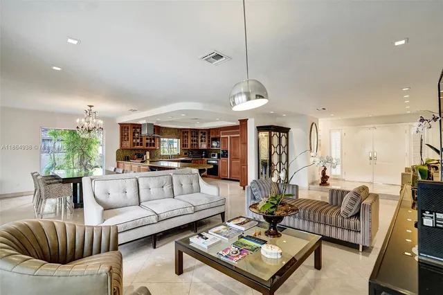 a living room with furniture kitchen view and a chandelier