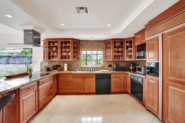 a large kitchen with stainless steel appliances granite countertop a stove and a sink
