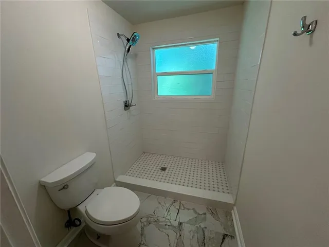 a bathroom with a toilet and a shower
