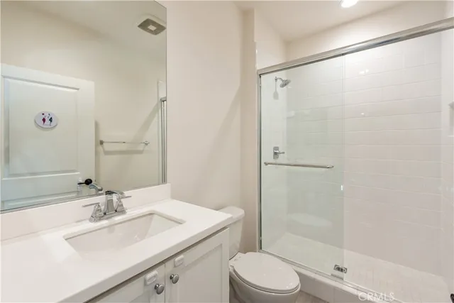 a bathroom with a sink toilet vanity and shower