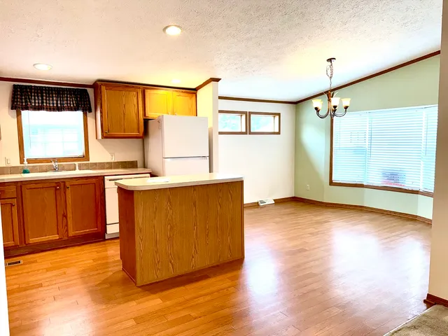 a kitchen with stainless steel appliances granite countertop a sink and a wooden floor