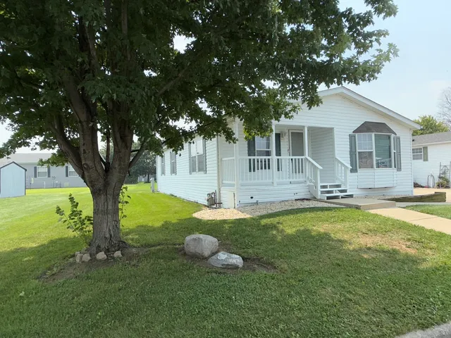 a view of a house with backyard and a tree