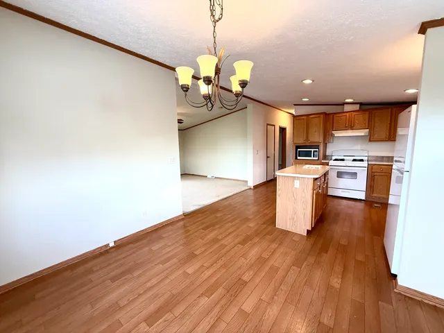 a kitchen with stainless steel appliances granite countertop a wooden floors a stove and a wooden floors