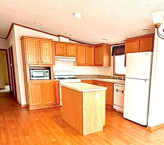 a kitchen with a refrigerator a stove top oven a sink and cabinets