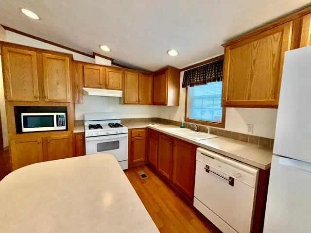 a kitchen with granite countertop a sink stainless steel appliances and cabinets