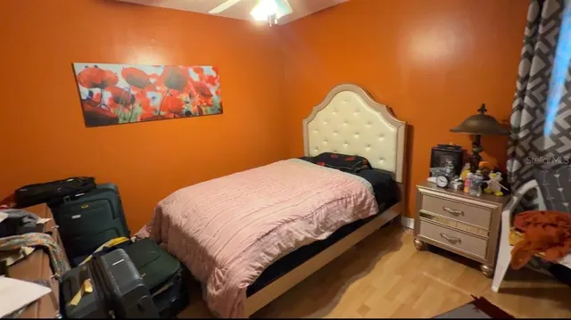 a bedroom with a bed and a painting on the wall