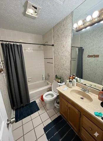 a bathroom with a sink a toilet a mirror and shower