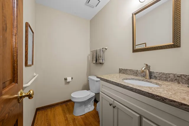 a bathroom with a granite countertop toilet sink and mirror