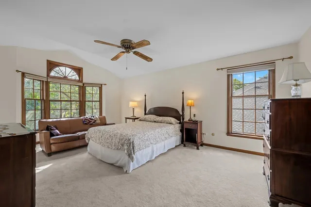 a spacious bedroom with a bed a couch and large window