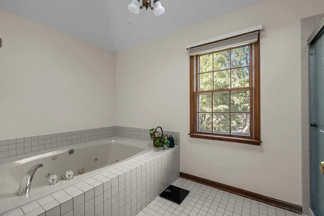 a bathroom with a tub a sink and a window