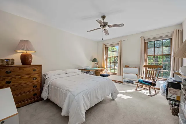 a bedroom with a bed a chandelier and a mirror on dresser
