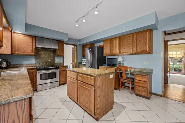 a kitchen with granite countertop a stove top oven microwave and cabinets