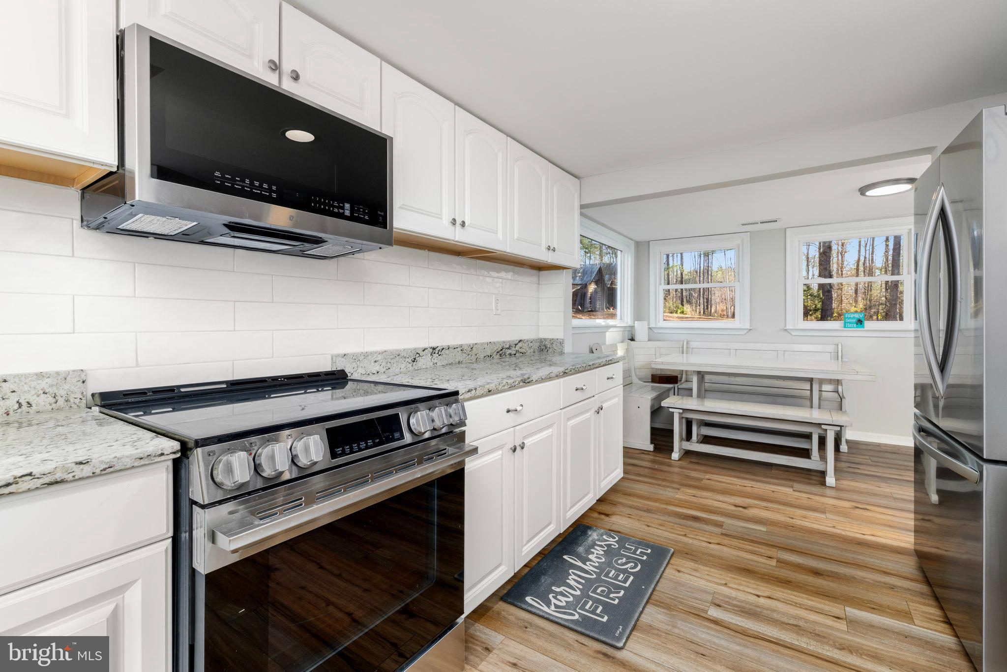 1052 South Hill Road Brodnax, VA 23920 - Photo 18 of 100 a kitchen with granite countertop a stove and a microwave