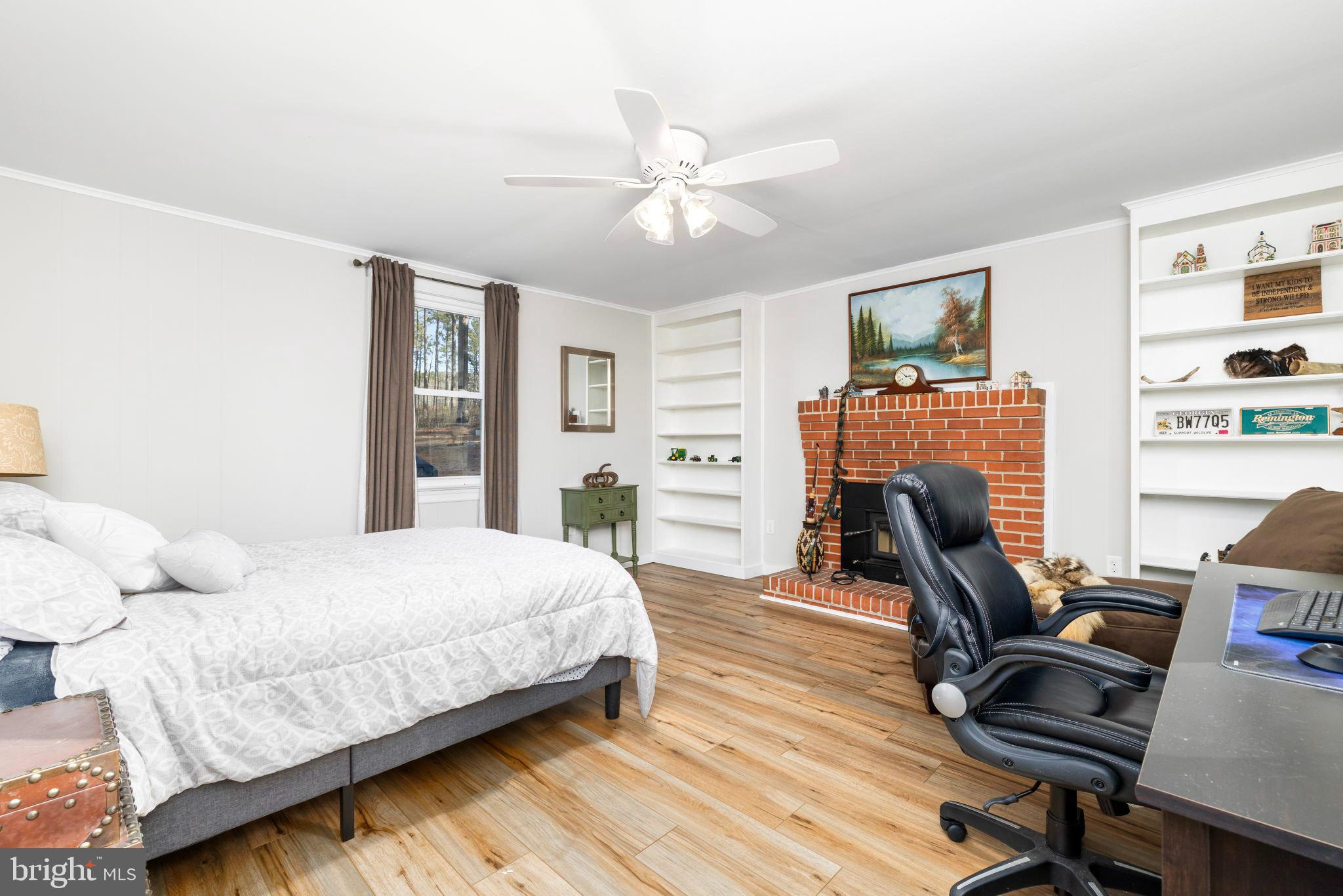 1052 South Hill Road Brodnax, VA 23920 - Photo 21 of 100 a bedroom with a bed a desk and chair with wooden floor