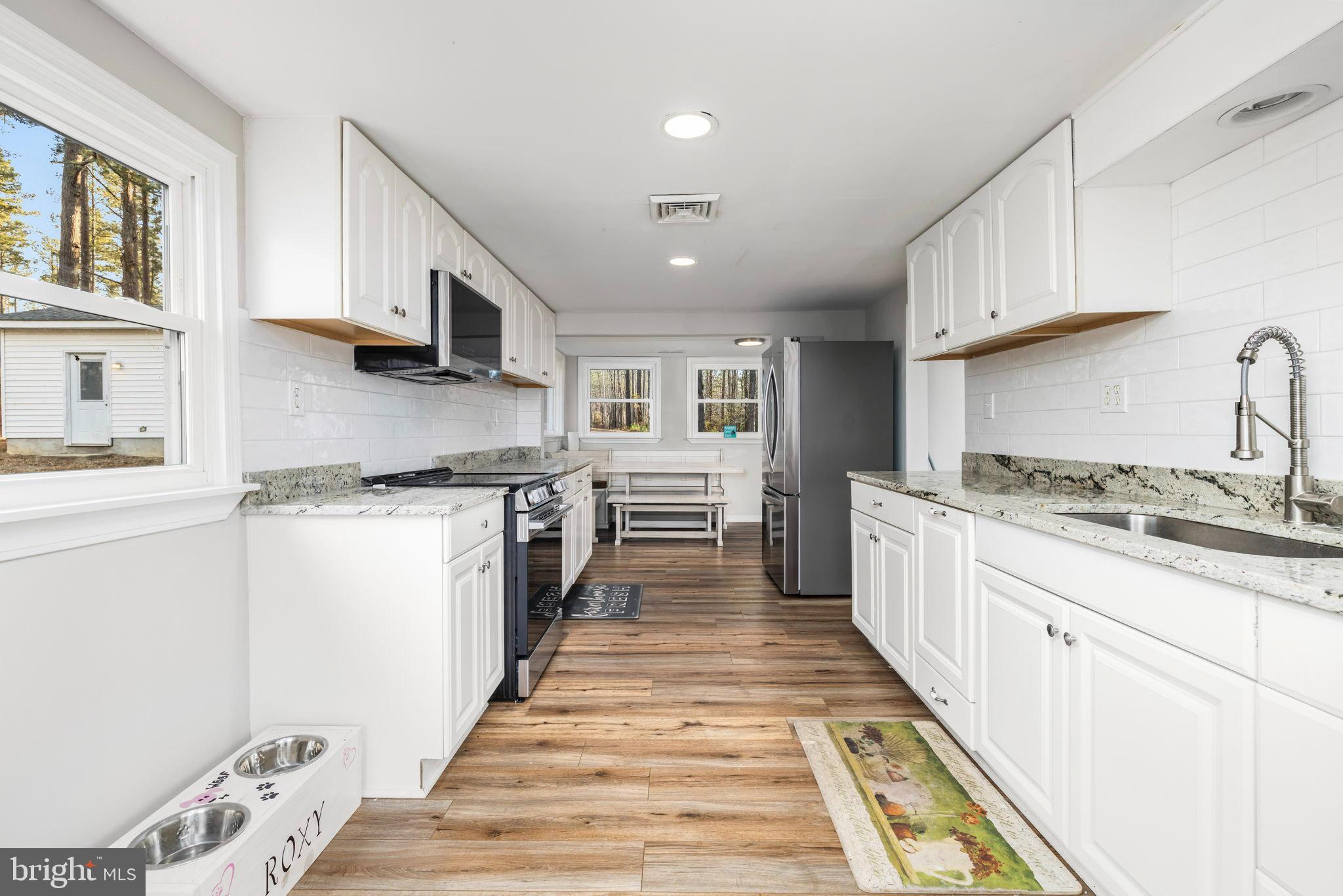 1052 South Hill Road Brodnax, VA 23920 - Photo 33 of 100 a kitchen with stainless steel appliances granite countertop a stove a sink and a refrigerator