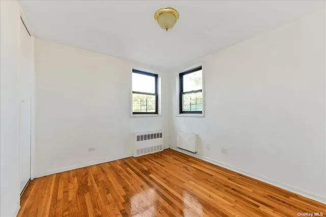a view of empty room with window and cabinet