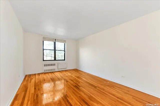 an empty room with wooden floor and a window