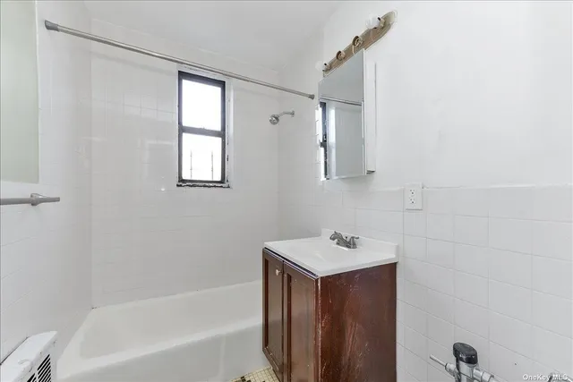 a bathroom with a bathtub sink vanity and mirror