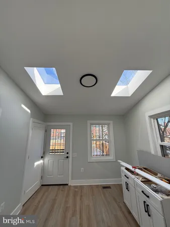 a view of empty room with window and wooden floor