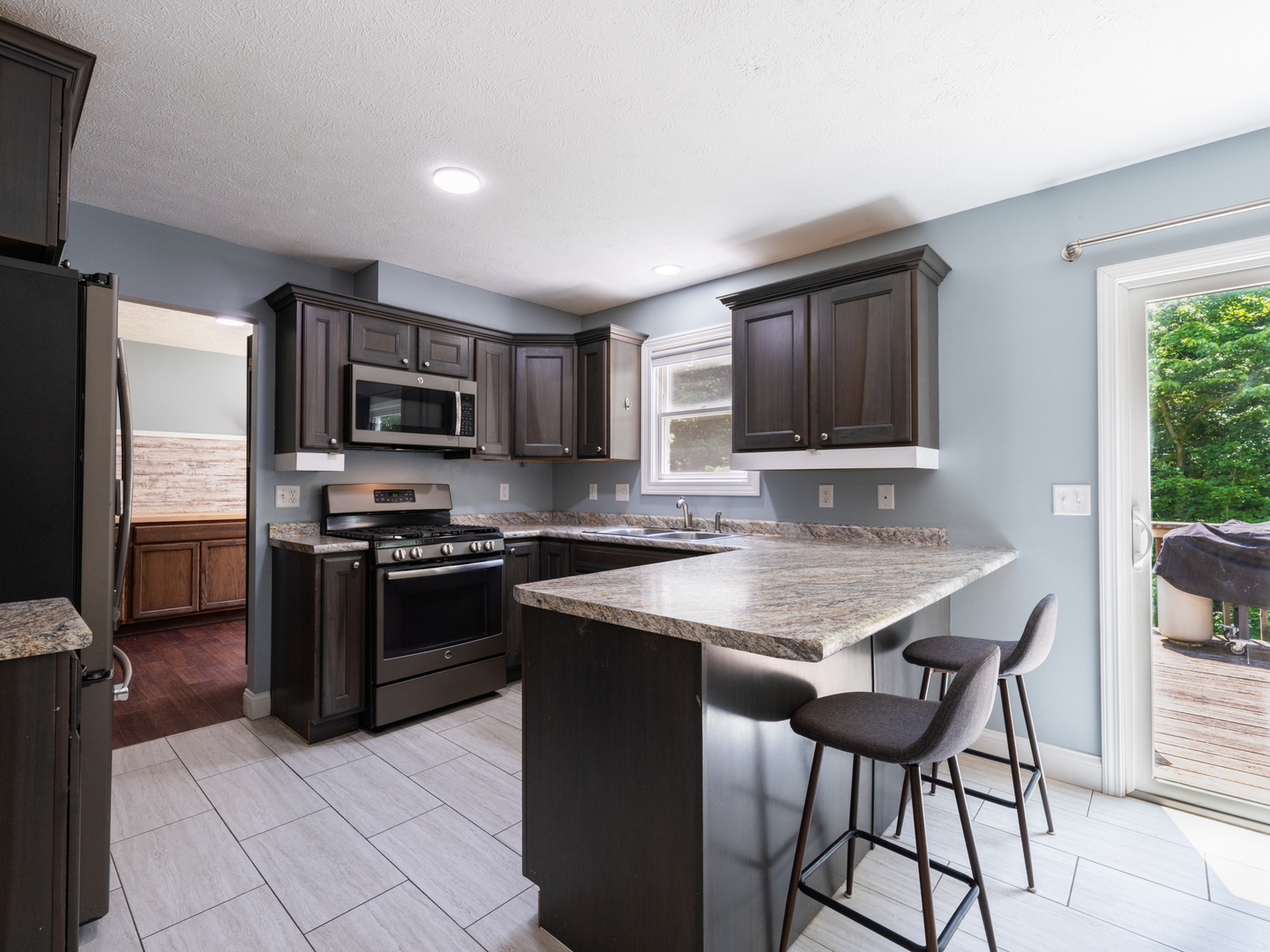 25 Greenbriar Road Mackinaw, IL 61755 - Photo 7 of 51 a kitchen with stainless steel appliances granite countertop a stove top oven a sink dishwasher a dining table and chairs with wooden floor