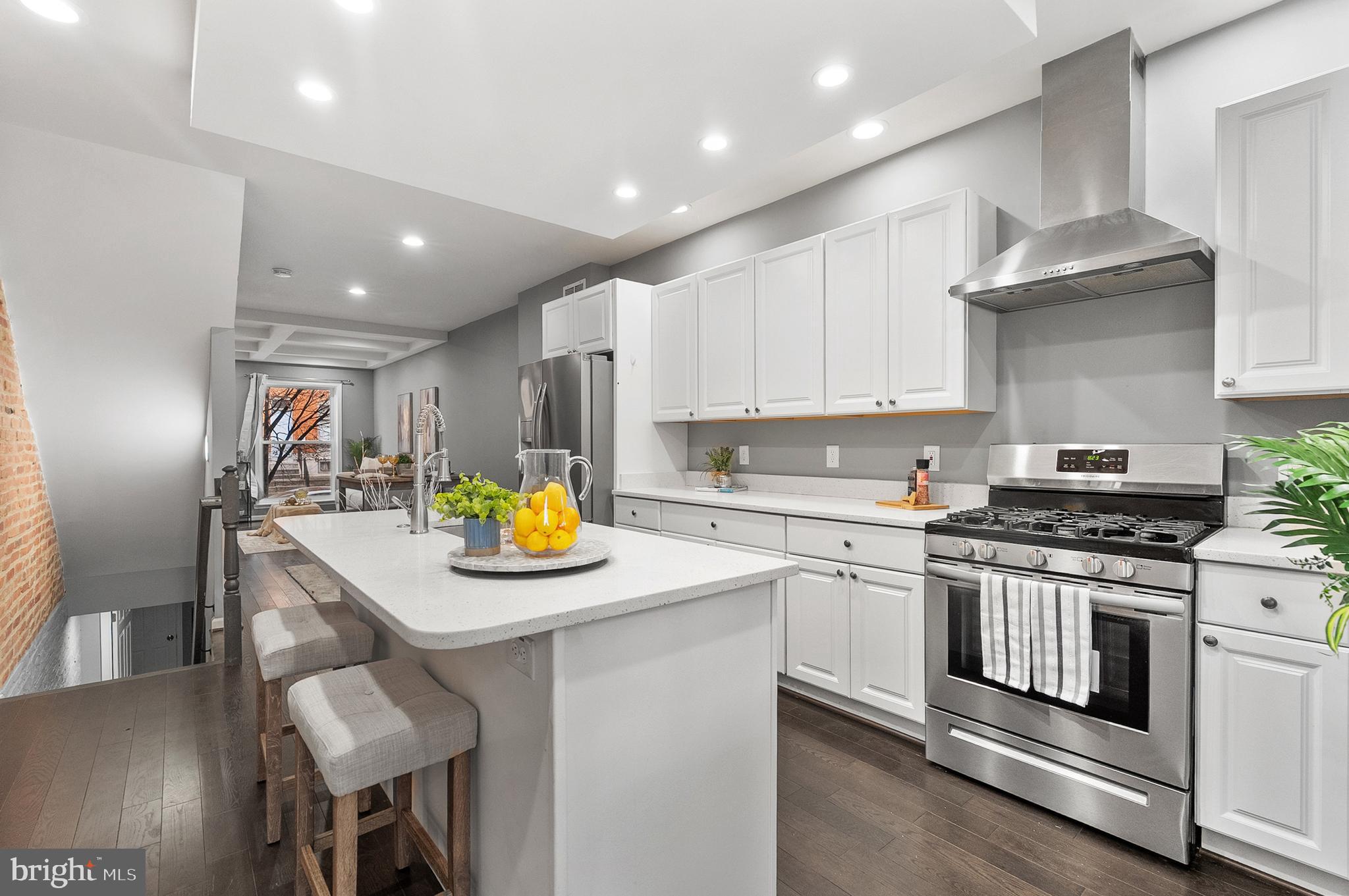 632 South Macon Street Baltimore, MD 21224 - Photo 3 of 20 a kitchen with stainless steel appliances kitchen island granite countertop a stove a sink a refrigerator and white cabinets