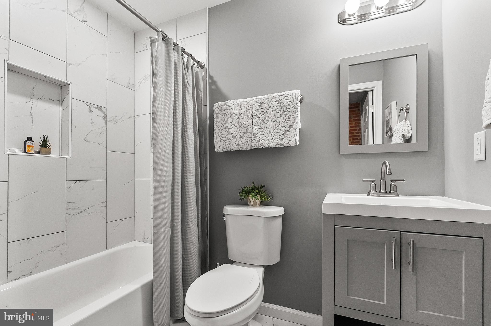 632 South Macon Street Baltimore, MD 21224 - Photo 10 of 20 a bathroom with a toilet sink vanity tub and shower