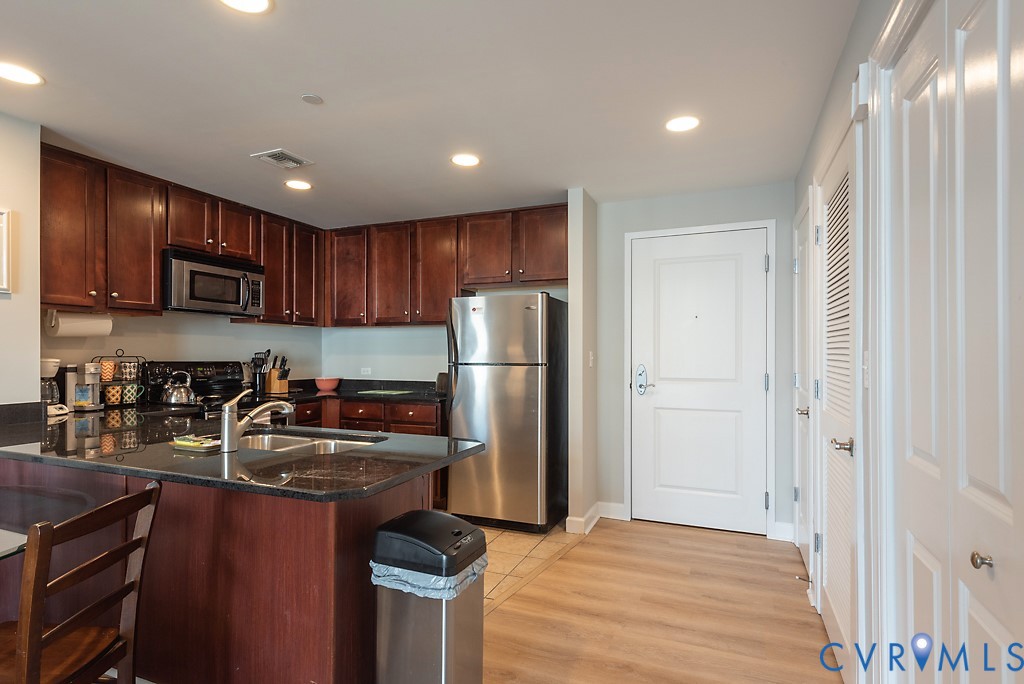 1101 Haxall Point, Unit 703 Richmond, VA 23219 - Photo 3 of 34 a kitchen with stainless steel appliances granite countertop a refrigerator stove and sink