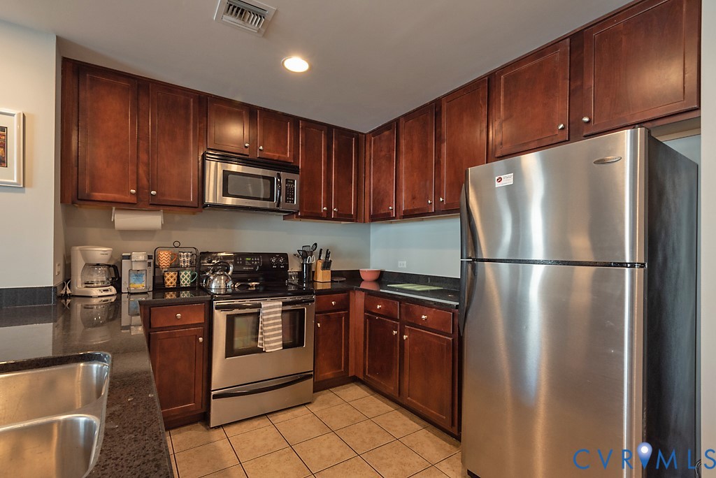 1101 Haxall Point, Unit 703 Richmond, VA 23219 - Photo 6 of 34 a kitchen with stainless steel appliances granite countertop a refrigerator stove a sink dishwasher and microwave