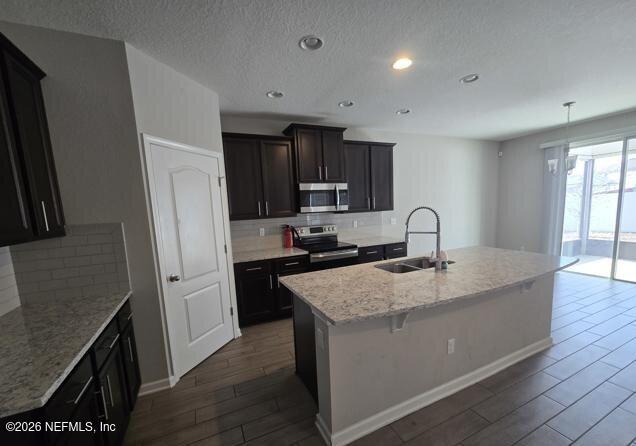 8182 Dancing Fox Street Jacksonville, FL 32222 - Photo 4 of 11 a kitchen with stainless steel appliances granite countertop a sink stove and refrigerator