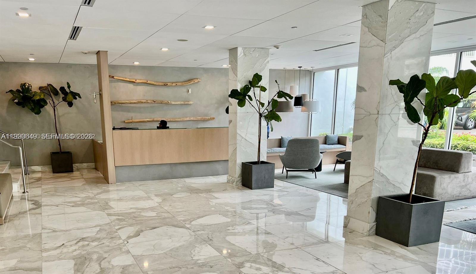 199 Ocean Ln Drive, Unit 102 Key Biscayne, FL 33149 - Photo 15 of 26 a living room with furniture a potted plant and kitchen view