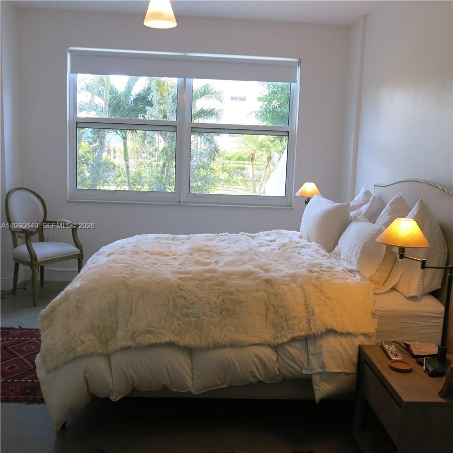 199 Ocean Ln Drive, Unit 102 Key Biscayne, FL 33149 - Photo 4 of 26 a bedroom with a bed and a lamp next to a window
