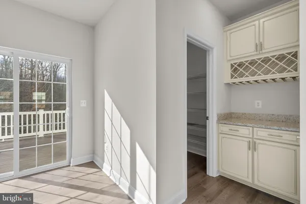 a view of a kitchen with wooden floor and cabinets