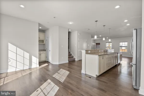 a large white kitchen with a large window and stainless steel appliances