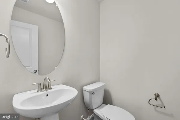 a bathroom with a toilet a sink and mirror