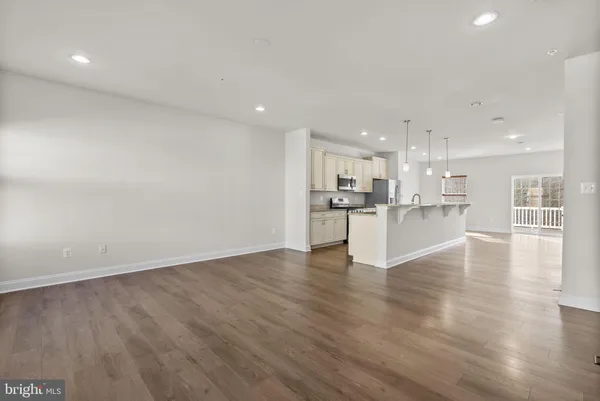 a view of kitchen with kitchen island and stainless steel appliances refrigerator oven with wooden floor