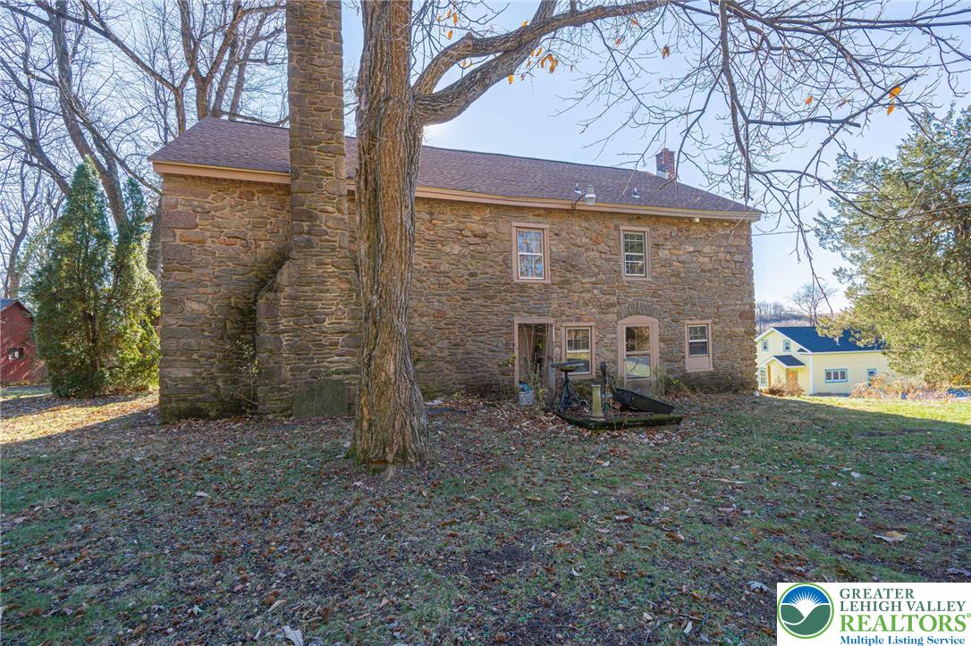 621 Nursery Road Kempton, PA 19529 - Photo 47 of 64 a view of a backyard with brick wall and a large tree