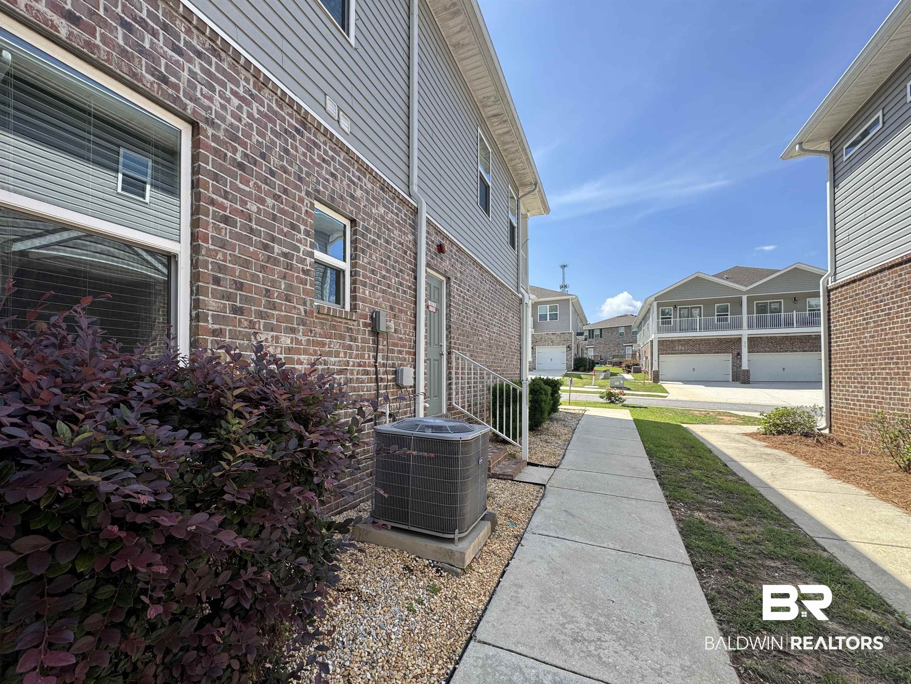 6811 Spaniel Drive, Unit C Daphne, AL 36527 - Photo 28 of 33 View of side of property featuring central AC, brick siding, and a residential view