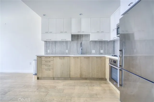 a kitchen with white cabinets and stainless steel appliances