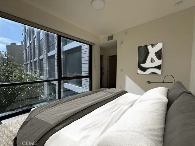 a bedroom with a large bed and a large window